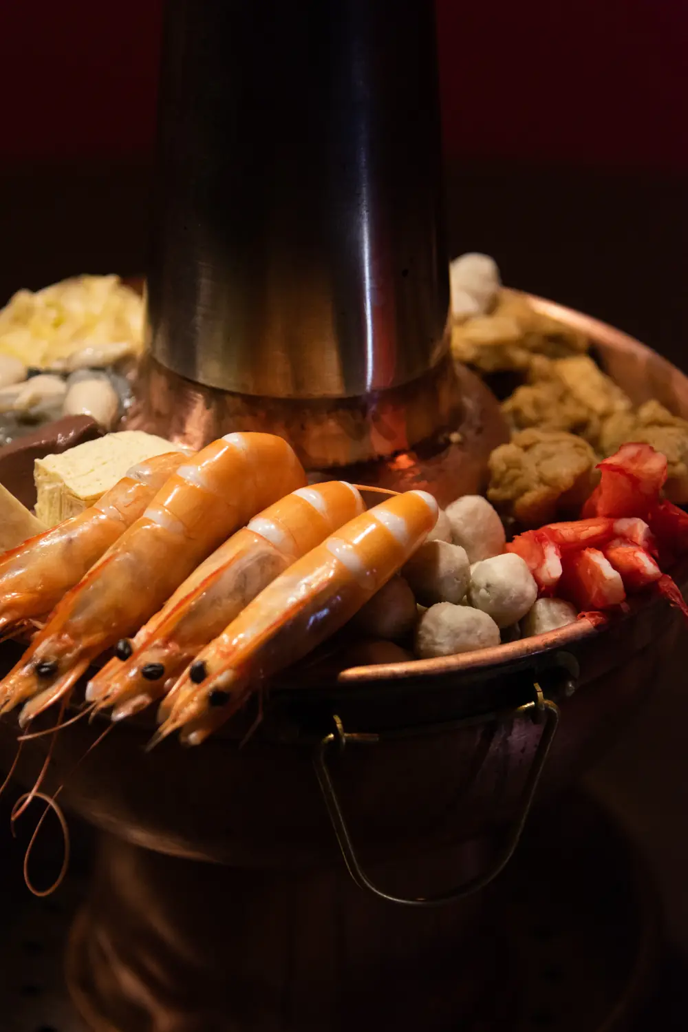 剛上桌的酸菜白肉鍋：鮮蝦、丸子、凍豆腐擺滿銅鍋