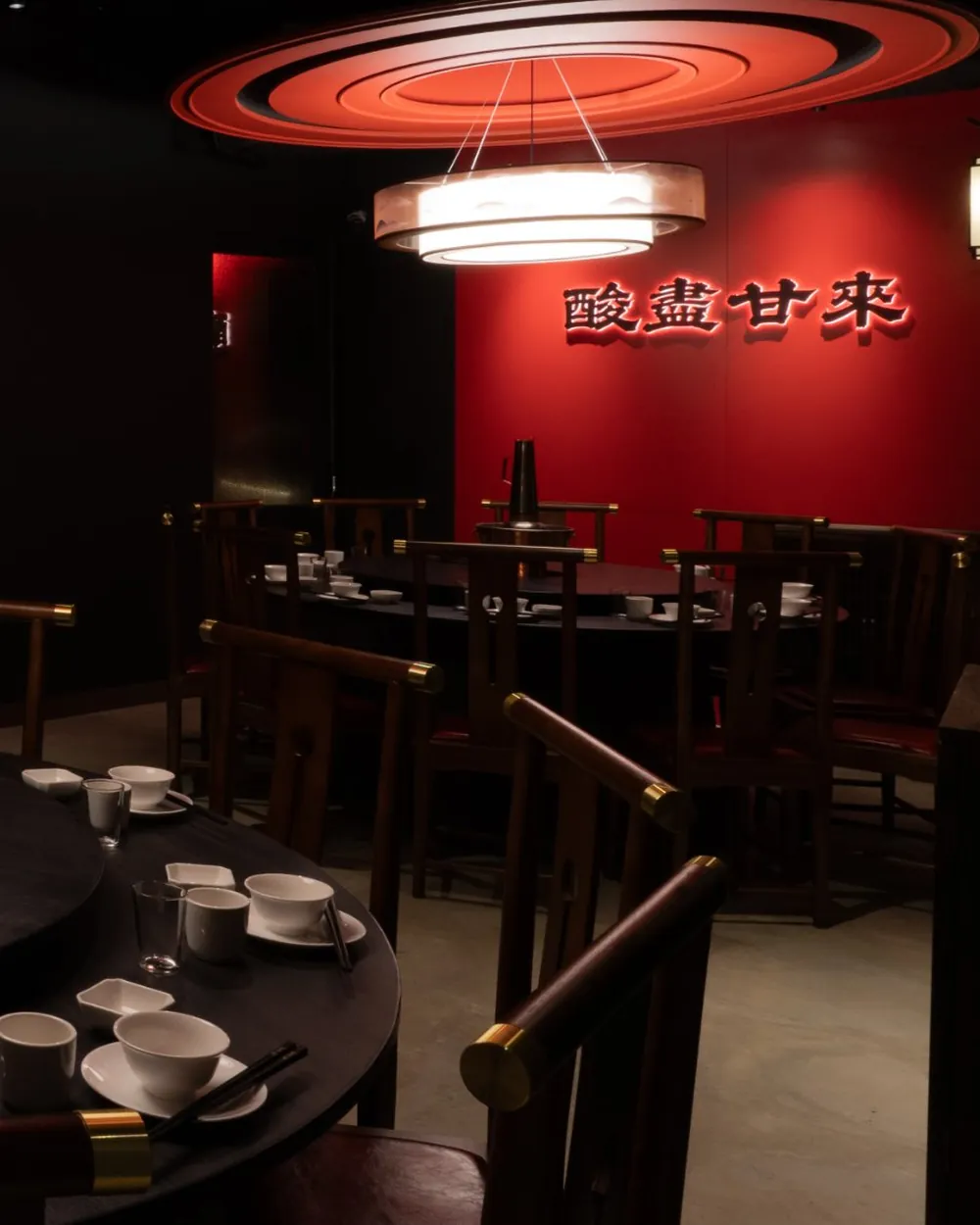 四平聚包廂：朱紅牆上掛著「酸盡甘來」，吊燈下官帽椅圍著圓桌