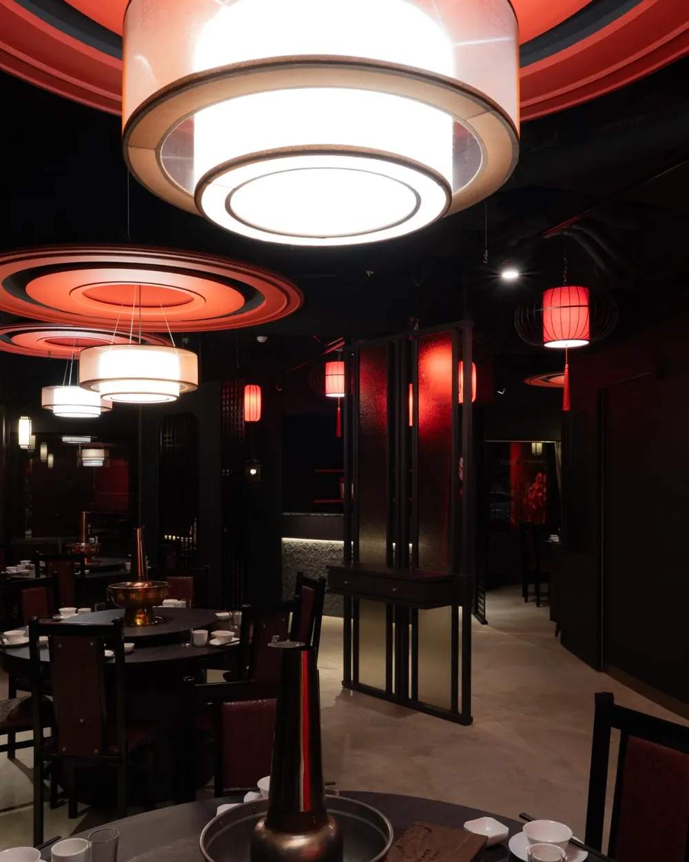 四平聚半開放用餐區：圓形吊燈下的一張張圓桌與炭火銅鍋